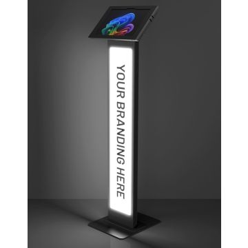 Studiofoto van de zwarte Compulocks BrandMe Lumina Apex vloerstandaard voor Microsoft Surface Pro 11 met verlicht reclamepaneel in een schuine hoek.